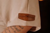 Détail de la pièce de cuir sur manche gauche T-Shirt épaule dénudéee