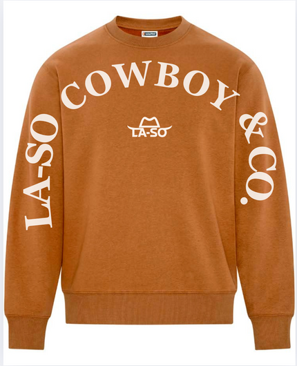 Un chandail caramel à manches longues avec le texte de couleur ivoire LA-SO COWBOY & CO. sur le devant et les manches. Le logo central LA-SO est surmonté d’un chapeau cowboy stylisé. Style affirmé et country chic.