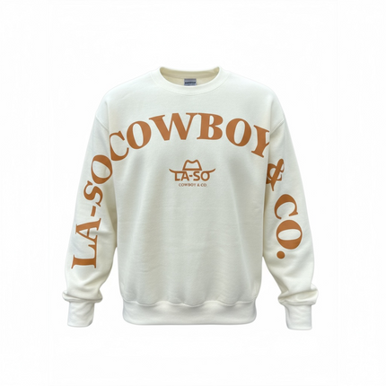 Un chandail ivoire à manches longues avec le texte de couleur caramel LA-SO COWBOY & CO. sur le devant et les manches. Le logo central LA-SO est surmonté d’un chapeau cowboy stylisé. Style affirmé et country chic.